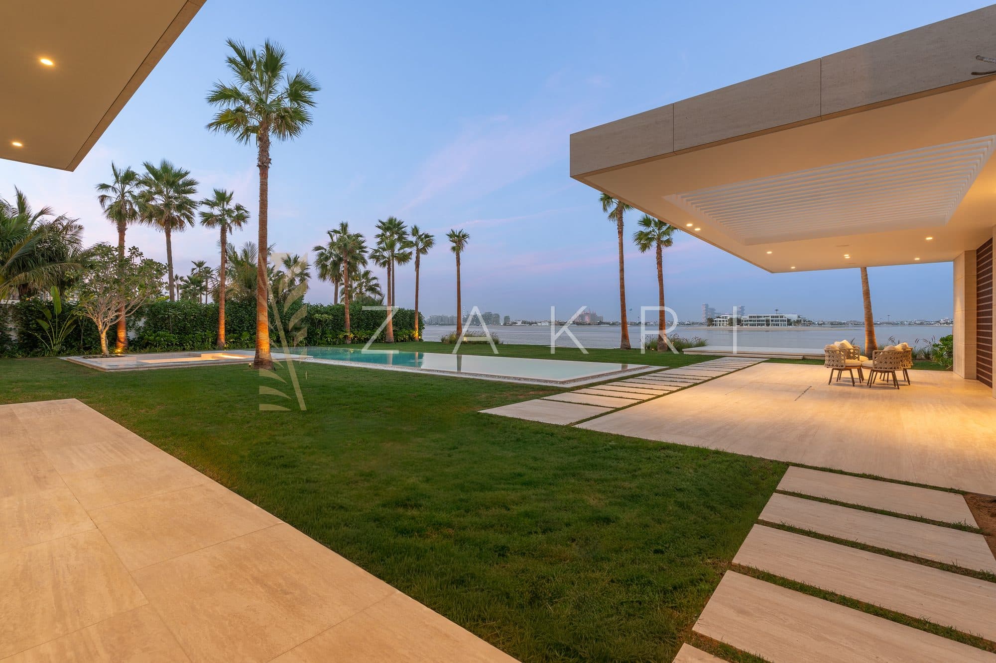 The covered terrace and lawn running down to the water