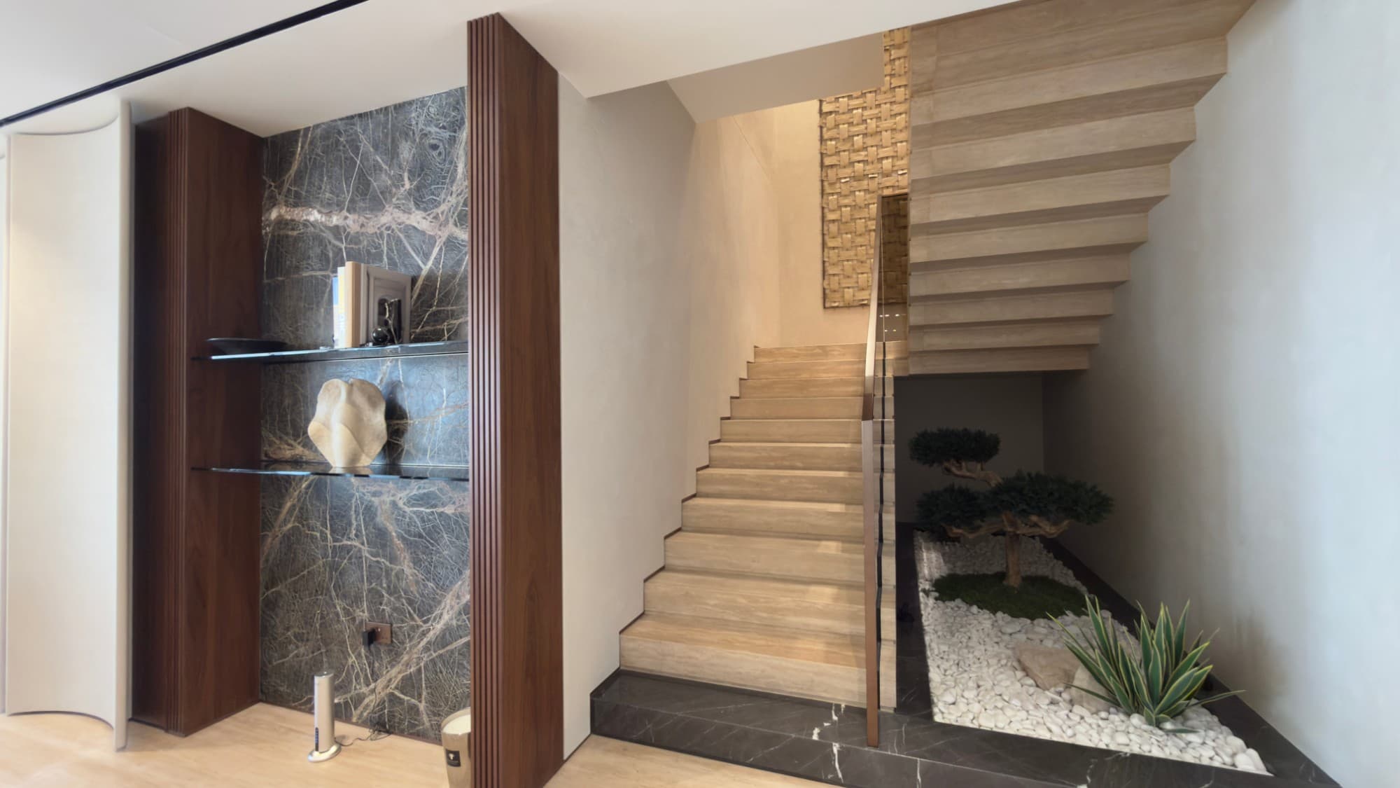 The travertine stair between the two floors, beside a planted courtyard