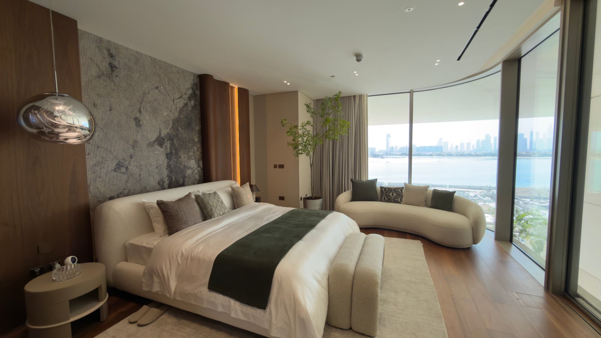 The master bedroom, curved glazing to the sea and the city