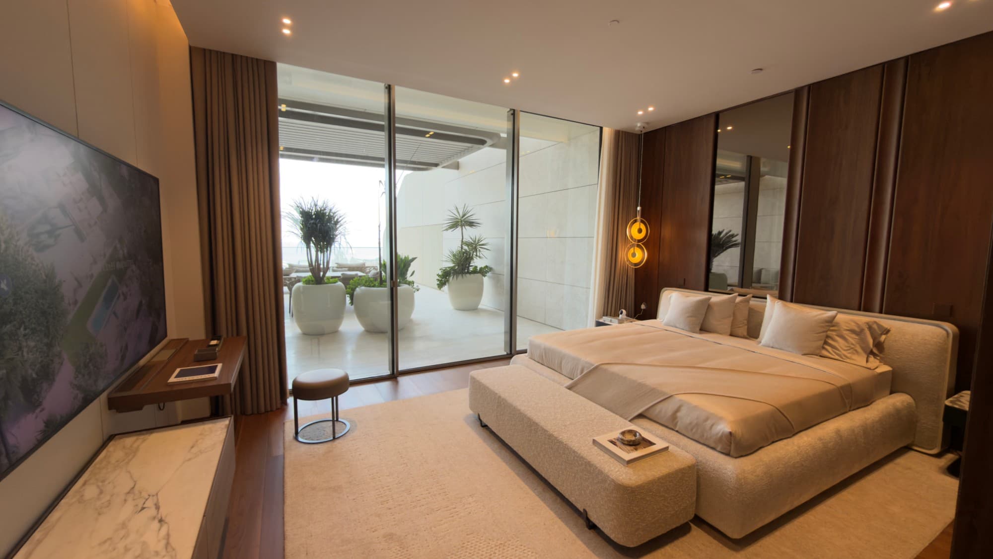 A bedroom with its walnut wardrobe wall, glazed the full height to the terrace