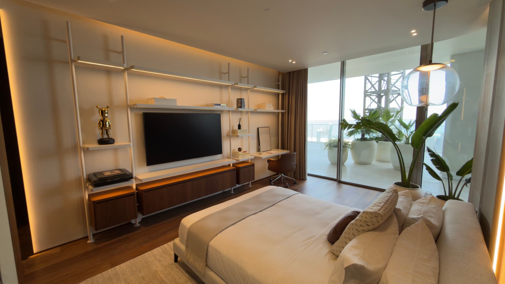 A bedroom with open shelving, a desk and its own stretch of terrace