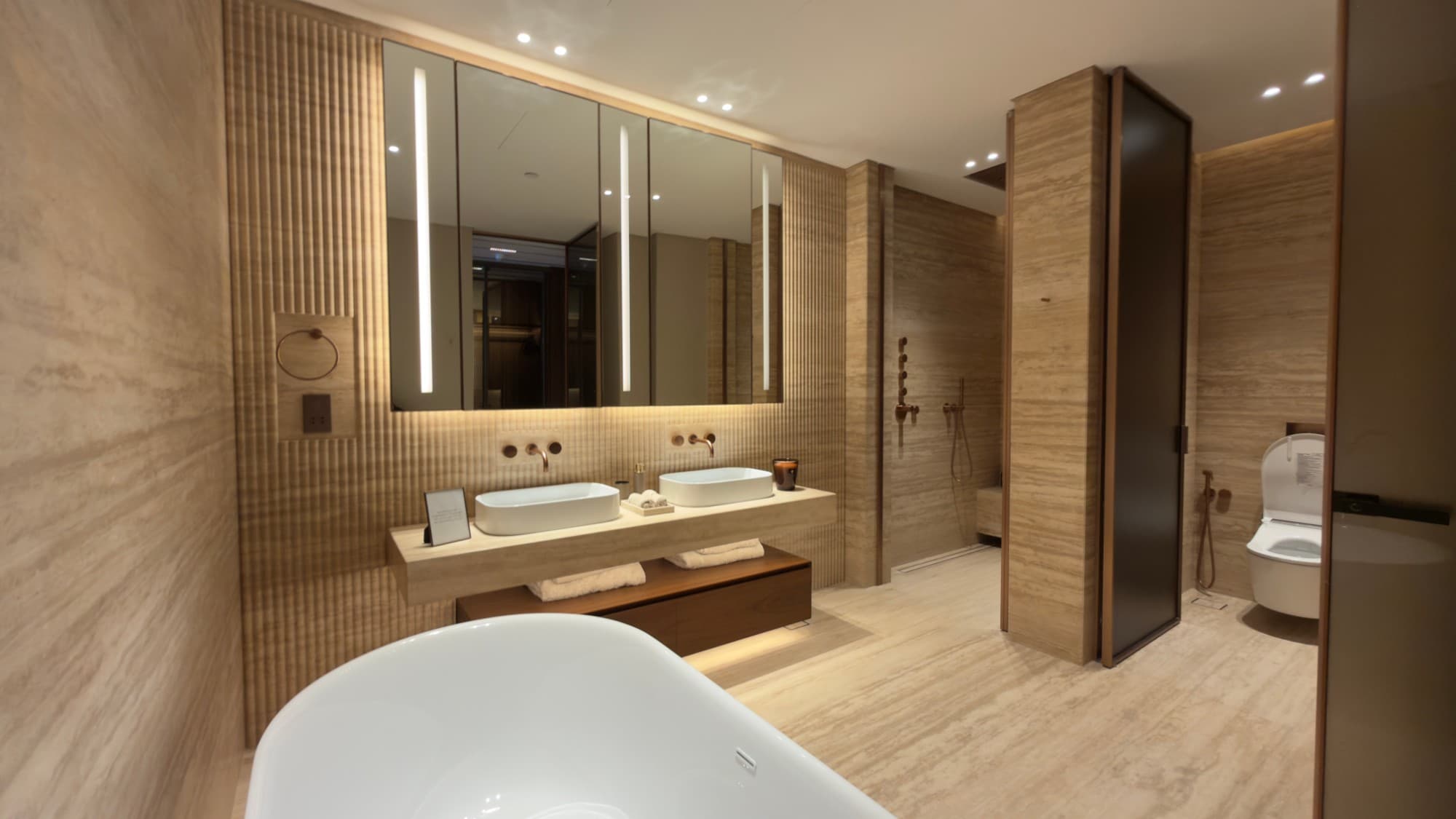 The principal bathroom in vein-cut travertine, with a freestanding bath
